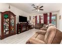 Spacious living room featuring tile floors, ceiling fan, and comfortable reclining sofa at 18241 W Foothill Dr, Surprise, AZ 85387