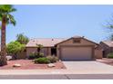 Inviting single-story home with a well-kept front yard and a two-car garage, on a sunny day at 20769 N 106Th Ln, Peoria, AZ 85382