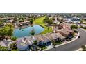 An aerial view shows the property on a green golf course with a beautiful lake nearby at 21480 N 56Th Ave, Glendale, AZ 85308
