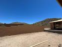 New home backyard with block fence and mountain views in construction phase at 27358 N 69Th Dr, Peoria, AZ 85383