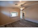 Spacious living room featuring sleek laminate floors, neutral walls, and a ceiling fan at 310 E Payton St, San Tan Valley, AZ 85140