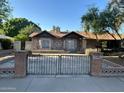 Inviting home with a distinctive stone facade, wrought iron gate, and established landscaping at 344 E Aepli Dr, Tempe, AZ 85282
