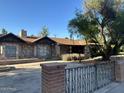 Charming home with stone accents, a well-kept yard, and a decorative wrought iron gate at 344 E Aepli Dr, Tempe, AZ 85282