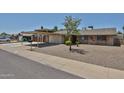 Inviting single-story home featuring a desert landscape, covered parking, and brick exterior at 3802 W Kelton Ln, Phoenix, AZ 85053