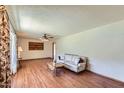Inviting living room with wood laminate floors, a comfortable couch, and a vintage ceiling fan at 3944 E Oak St, Phoenix, AZ 85008