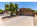 Inviting single-Gathering home featuring lush landscaping, a mature shade tree, and an attached two-car garage at 42551 W Anne Ln, Maricopa, AZ 85138