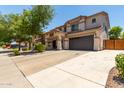 Wide driveway leading to a two-story home with a spacious two-car garage and well-manicured landscaping at 44517 W Copper Trl, Maricopa, AZ 85139