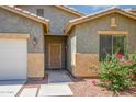 Close-up of a front exterior showing desert landscaping, secured entrance, and a view of the garage at 45391 W Portabello Rd, Maricopa, AZ 85139