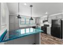 Well-lit kitchen featuring a central island, modern pendant lighting, and stylish appliances at 701 S Dobson Rd # 447, Mesa, AZ 85202