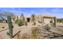 Beautiful home exterior with desert landscaping, native cacti, and a private gated entrance at 9802 E Hidden Valley Rd, Scottsdale, AZ 85262