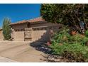 View of the house's three-car garage featuring decorative stone accents at 10413 E Emelita Ave, Mesa, AZ 85208