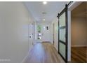 Inviting entryway featuring wood-look tile floors, a glass sliding barn door and ample natural light at 16447 W Cottonwood St, Surprise, AZ 85388