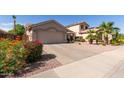 Inviting single-Gathering home with a well-maintained lawn and a two-car garage, surrounded by lush landscaping at 16554 W Saguaro Ln, Surprise, AZ 85388