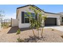Home with a two-car garage, desert landscaping, and block wall fencing at 17830 W Mission Ln, Waddell, AZ 85355