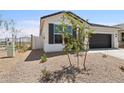 Single-story home with desert landscaping, a two-car garage, and block wall fencing at 17830 W Mission Ln, Waddell, AZ 85355