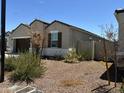 View of a home with brown desert landscaping and neutral paint at 18765 W Adams St, Buckeye, AZ 85326