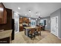 Open kitchen with dark wood cabinetry, granite counters, stainless steel appliances and breakfast bar island at 20194 N Riverbank Rd, Maricopa, AZ 85138