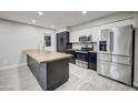 Modern kitchen with stainless steel appliances, black and white cabinets and large center island at 2122 E Radcliffe Dr, Tempe, AZ 85283