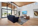 Bright living room with floor to ceiling windows, wood ceiling, hardwood floors, and modern furnishings at 24724 N 119Th Pl, Scottsdale, AZ 85255