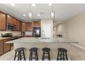 Granite kitchen island with a stainless steel sink and seating for four at 25969 W Tina Ln, Buckeye, AZ 85396
