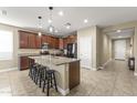 An open-concept kitchen with dark wood cabinets, granite countertops, and stainless steel appliances at 25969 W Tina Ln, Buckeye, AZ 85396