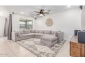 Bright living room with a large sectional sofa, ceiling fan, and decorative elements at 37287 N Azteca Rd, San Tan Valley, AZ 85140