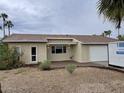 Charming single-story home featuring a desert landscape, attached garage, and a covered front patio area at 4910 E Charter Oak Rd, Scottsdale, AZ 85254