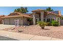 Charming single-story home featuring a red tile roof, a three-car garage, and desert landscaping at 608 E Stonebridge Dr, Gilbert, AZ 85234