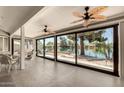 Spacious sunroom with waterfront views, tiled floor, and ceiling fans for comfortable indoor/outdoor living at 608 E Stonebridge Dr, Gilbert, AZ 85234
