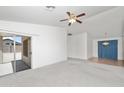 Spacious living room with neutral carpet, vaulted ceiling, and sliding door access to a covered patio at 742 E Lovegrass Dr, San Tan Valley, AZ 85143