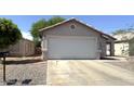 Single-story home featuring a two-car garage with a desert landscape at 8308 W Baxter Dr, Phoenix, AZ 85037