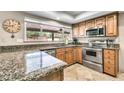 Kitchen featuring stainless steel appliances, granite countertops, tile flooring, and a window overlooking the backyard at 8532 E San Bruno Dr, Scottsdale, AZ 85258