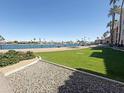 Beautiful backyard overlooking a lake with palm trees and a green lawn at 10330 W Thunderbird Blvd # B112, Sun City, AZ 85351