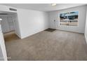 A well-lit living room showcases a spacious layout and new neutral carpeting at 10831 W Heatherbrae Dr, Phoenix, AZ 85037