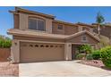 Beige two story house with a well maintained front yard at 12274 W Monroe St, Avondale, AZ 85323