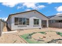 The back of the house features a small patio and desert landscaping under a bright, sunny sky at 12375 W Whyman Ave, Avondale, AZ 85323
