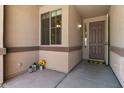 Charming front porch with decorative lanterns, potted flowers, and a welcoming door mat, creating curb appeal at 1321 E Monteleone St, San Tan Valley, AZ 85140