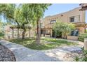 Attractive townhomes with manicured lawns, mature trees, and sidewalk, featuring gated pool area at 1446 E Grovers Ave # 13, Phoenix, AZ 85022