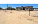 Spacious single story home with large dirt front yard, black metal fencing, and mature landscaping at 20310 W Hubbard Rd, Buckeye, AZ 85326