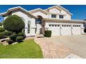 Inviting home with a three-car garage, beautiful lawn, and a walkway leading to the front door at 25015 N 50Th Ave, Phoenix, AZ 85083