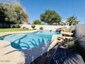Backyard pool with waterfall feature and a built-in table with seating at 25015 N 50Th Ave, Phoenix, AZ 85083