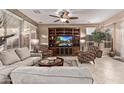 Spacious living room features neutral colors, a ceiling fan, and built-in entertainment center at 28878 N 127Th Ln, Peoria, AZ 85383
