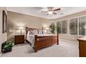 Inviting main bedroom with a ceiling fan, plush carpet, and a large window for natural light at 28878 N 127Th Ln, Peoria, AZ 85383