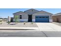 Charming single story home featuring a blue garage door and low maintenance desert landscaping at 37194 W La Paz St, Maricopa, AZ 85138