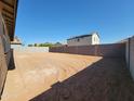 View of the large, blank canvas backyard area enclosed with a cinder block wall at 37212 W Parador Ln, Maricopa, AZ 85138