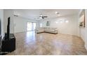 Bright and airy living room with tile flooring, a ceiling fan, and sliding glass doors to the backyard at 5130 W Molly Ln, Phoenix, AZ 85083