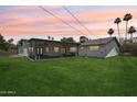 Expansive backyard with lush lawn, a covered patio, mature palm trees, and ample space for outdoor activities at 615 E Winter Dr, Phoenix, AZ 85020