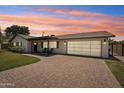Inviting home exterior featuring a brick driveway, glass garage door, covered patio, and charming curb appeal at 615 E Winter Dr, Phoenix, AZ 85020