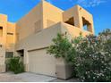 Two-story tan home with a tan garage door and desert plants at 9070 E Gary Rd # 152, Scottsdale, AZ 85260