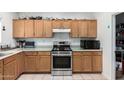 Functional kitchen with stainless steel appliances and wood cabinets, perfect for cooking at 9133 W Virginia Ave, Phoenix, AZ 85037